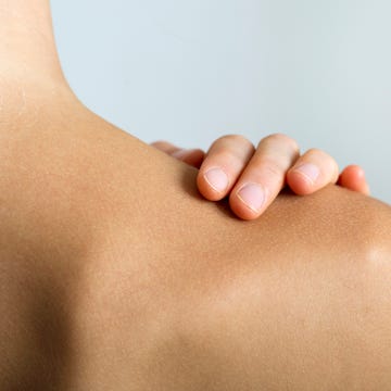 Woman with hand on bare shoulder, close-up Woman with hand on bare shoulder, close-up