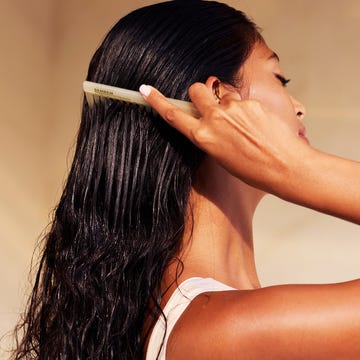 Woman Combing Long Wet Hair for Healthy and Smooth Haircare Routine woman hair care routine: a serene setting showcasing a woman with wet hair being gently brushed. emphasizing relaxation, beauty, and self care in a minimalist, sunlit environment.