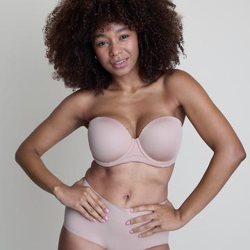Model posing in a strapless bra and high-waisted underwear against a neutral background. Model posing in a strapless bra and high-waisted underwear against a neutral background.