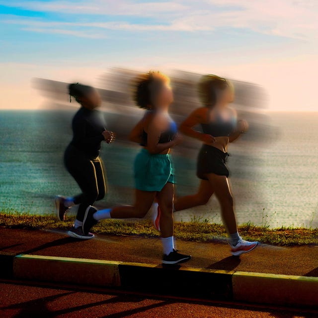 Group of runners jogging along a scenic coastal path during sunset, with blurred motion effect.
