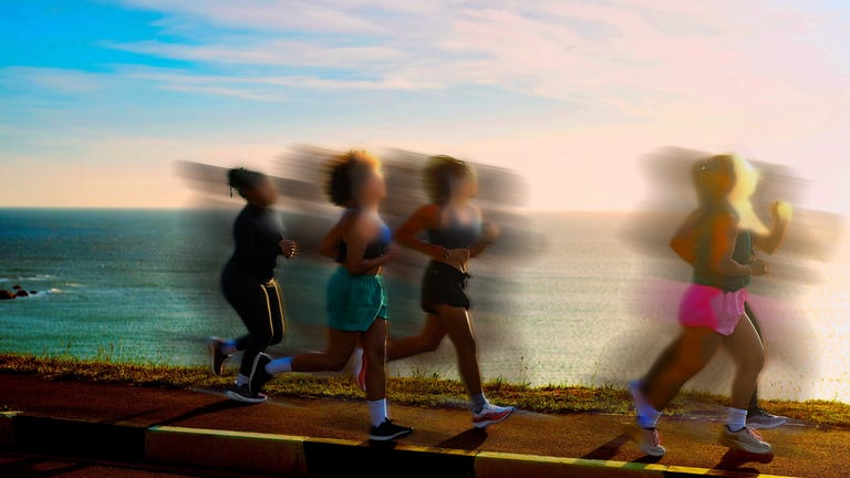 Group of runners jogging along a scenic coastal path during sunset, with blurred motion effect. Group of runners jogging along a scenic coastal path during sunset, with blurred motion effect.