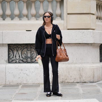 paris, france april 13: diane batoukina wears long straight brown hair, apple airpods max headsphones, black sunglasses by kaleos, a black zip up hoodie worn open by alo yoga, a black sports bra by alo yoga / cropped top, black sportswear flared pants by alo yoga, a brown leather bag by miu miu, black sneakers by alo yoga, during a street style fashion photo session, on april 13, 2026 in paris, france. (photo by edward berthelot/getty images)