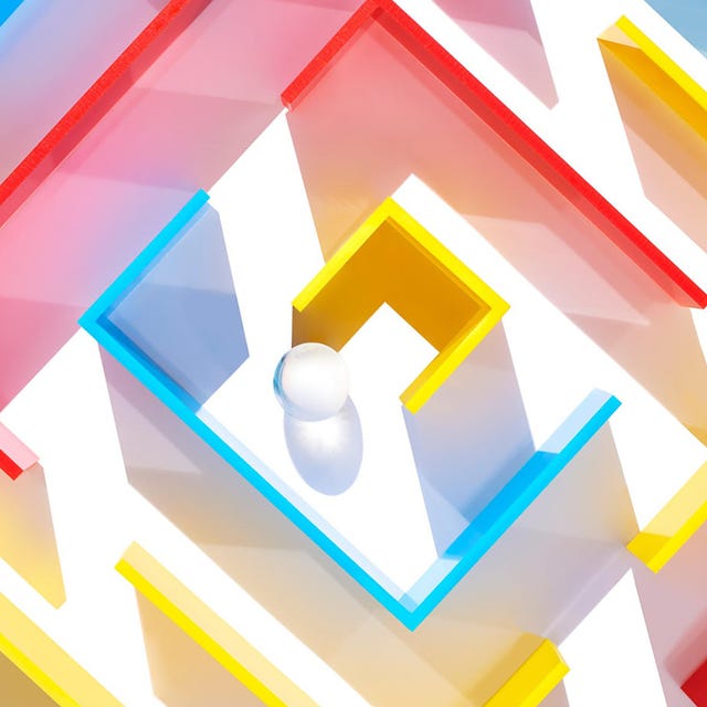 Colorful maze structure with a white ball in the center.
