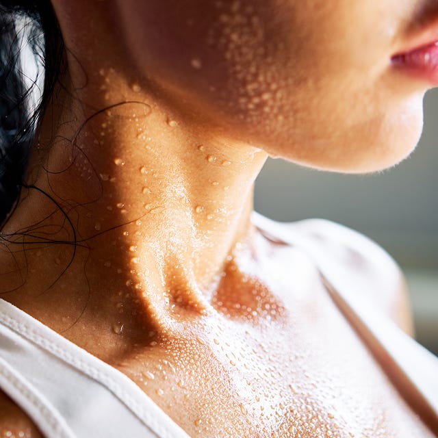 Close-up of a woman's neck and shoulder glistening with sweat.