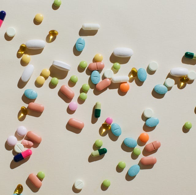 colorful pills and capsules on beige background. minimal medical concept. flat lay, top view.