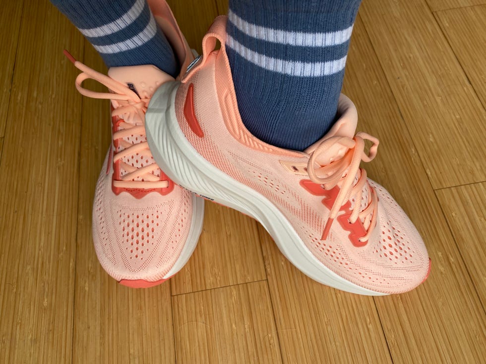 Peach running shoes paired with blue striped socks on a bamboo floor. Peach running shoes paired with blue striped socks on a bamboo floor.