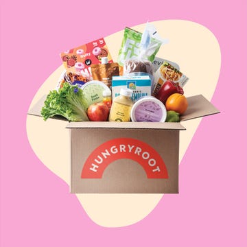 Grocery box with produce and packaged goods, next to a plated meal of sliced chicken, rice, and sauce.