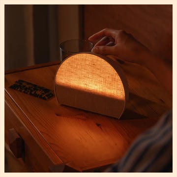 Modern sleep tracking lamp with soft lighting and a button indicating sleep tracking is enabled.