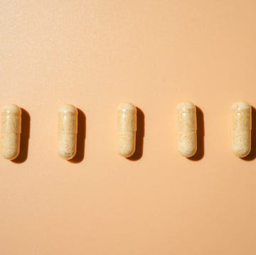 medicine capsules in a line on light beige, medical and healthcare, dietary supplements and vitamins