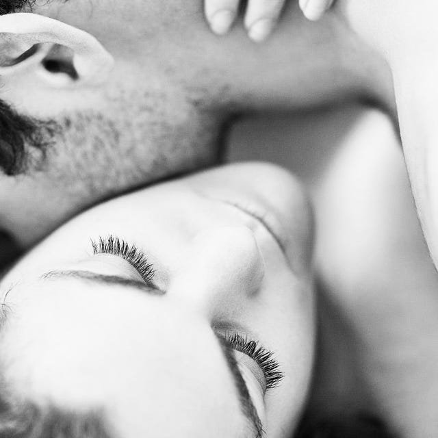 A close-up of a couple embracing, showcasing affection in a soft, black-and-white composition.