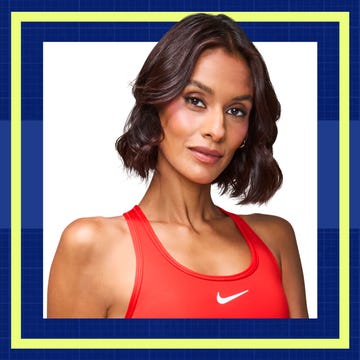 Woman in a red athletic top with short wavy hair, against a blue and white geometric background.