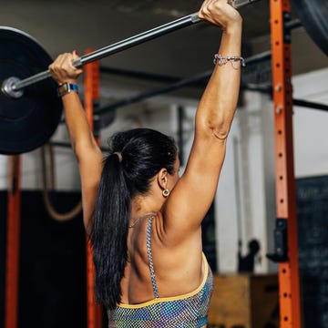 fitness determined mature woman working out at the gym concetrate middle aged lady doing daily exercises