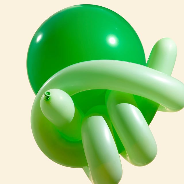 A cluster of green balloons in various shapes against a light background.
