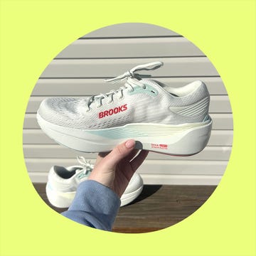 A pair of white and teal Brooks running shoes displayed from different angles, worn with gray leggings and white socks. A pair of white and teal Brooks running shoes displayed from different angles, worn with gray leggings and white socks.