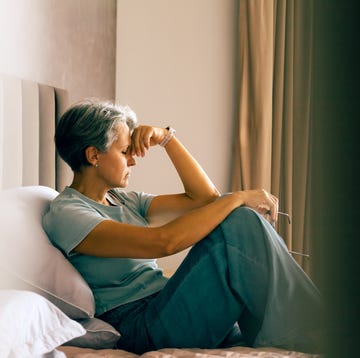 4 key menopause symptoms women should never ignore: woman overwhelmed sitting on a bed