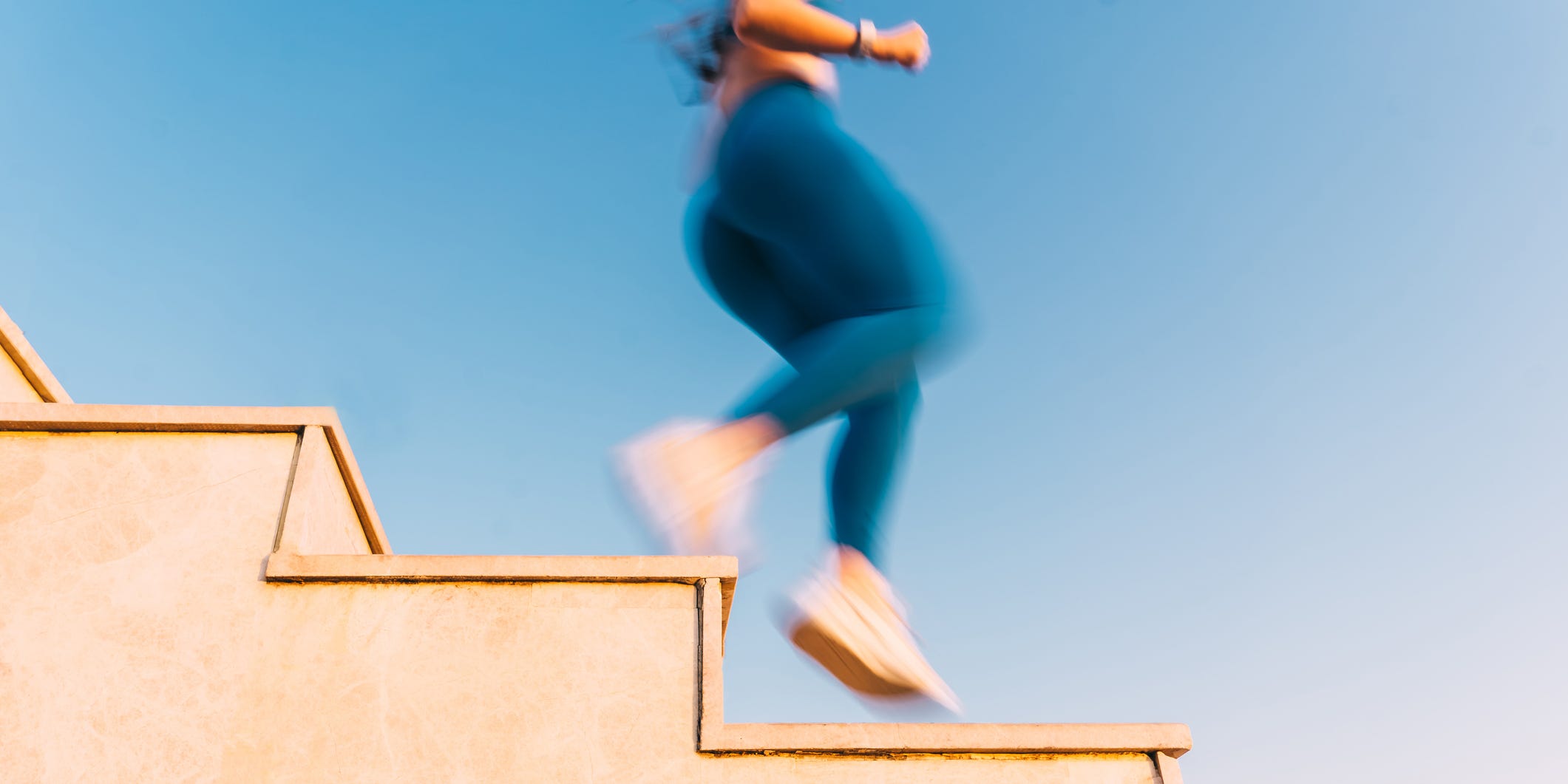 an abstract, motion blurred shot of a persons legs and feet running down a set of stairs the images dynamic feel captures the high energy and motion of a workout, symbolizing the relentless drive toward an active and healthy lifestyle