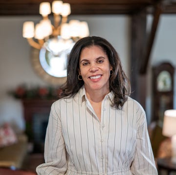 woman in a striped shirt standing in a warmly decorated room woman in a striped shirt standing in a warmly decorated room