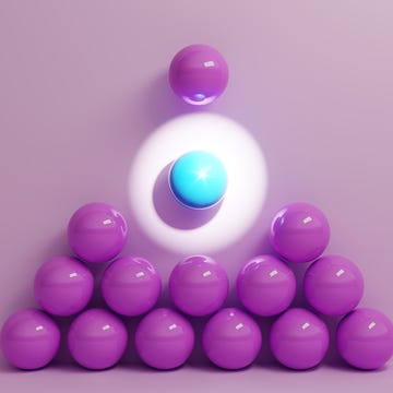 A cluster of purple and blue spheres arranged with dramatic lighting on a pale pink background. A cluster of purple and blue spheres arranged with dramatic lighting on a pale pink background.