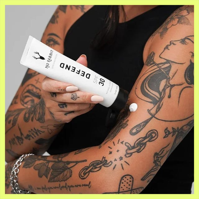 Two sunscreen products displayed: Hustle Butter SPF 50 stick and a bottle of Defend SPF 30 applied to a tattooed arm.