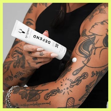 Two sunscreen products displayed: Hustle Butter SPF 50 stick and a bottle of Defend SPF 30 applied to a tattooed arm. Two sunscreen products displayed: Hustle Butter SPF 50 stick and a bottle of Defend SPF 30 applied to a tattooed arm.