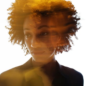 Silhouette of a person with curly hair against a bright background.
