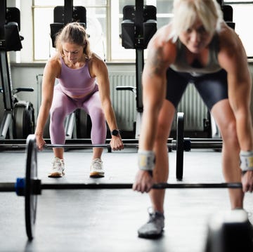 Female cross training athletes preparing for deadlift exercise in gym female cross training athletes preparing for deadlift exercise in gym