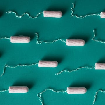a series of unused tampons against a teal background