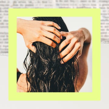 A person with long dark hair styling their hair with both hands, framed by a yellow border.
