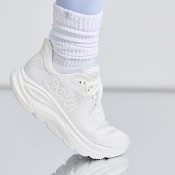White athletic shoe with a high sole and ankle-length socks.