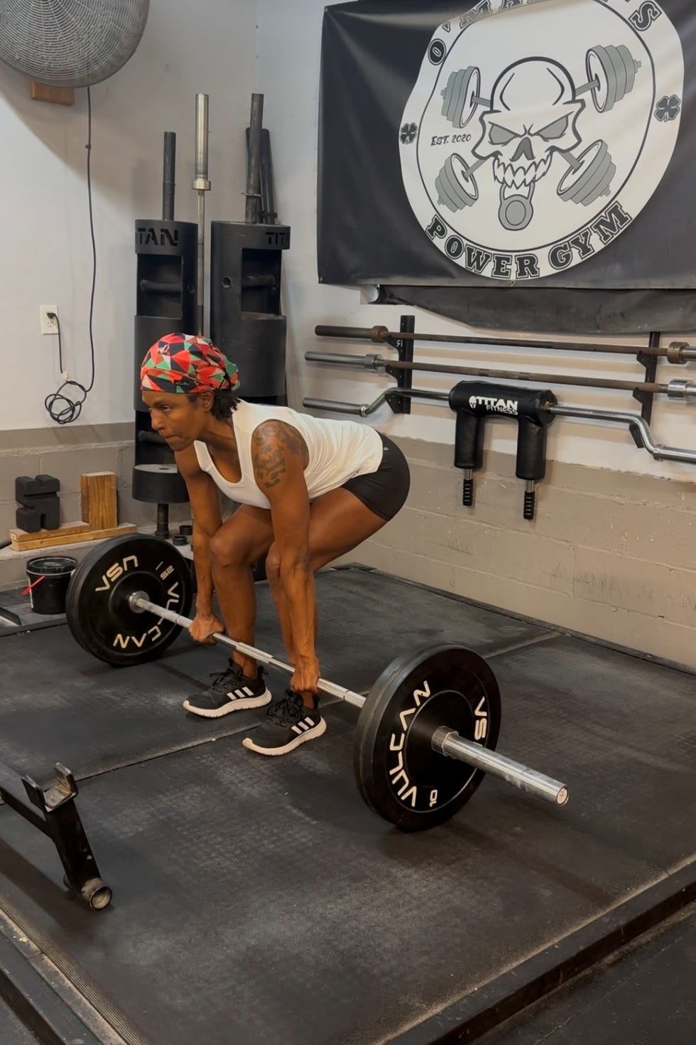 A person performing a deadlift in a gym, focused and preparing to lift a barbell from the floor. A person performing a deadlift in a gym, focused and preparing to lift a barbell from the floor.