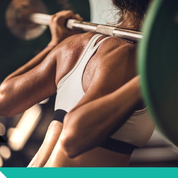 Weightlifter lifting a barbell in a gym, showcasing focused strength and athleticism.