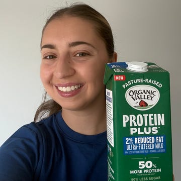Person smiling and holding a carton of Organic Valley Protein Plus milk. Person smiling and holding a carton of Organic Valley Protein Plus milk.