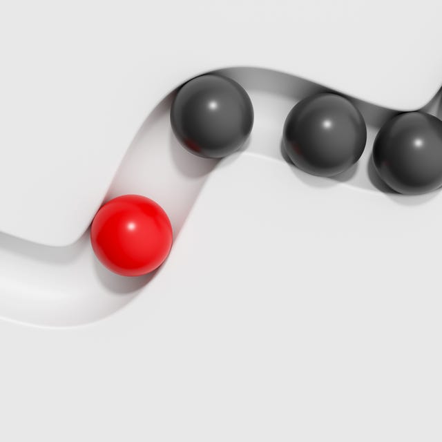 Abstract 3D conceptual background. Red sphere is separate from the black balls on white backdrop. Concept of leadership, confidence, aspirations, individuality, Standing Out From The Crowd.