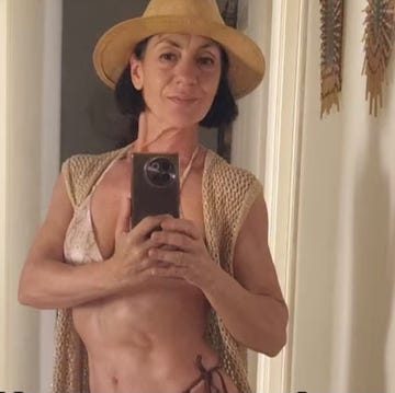 person wearing a hat and taking a selfie in a mirror.