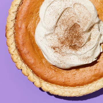 Fresh Baked Pumpkin Pie with Cinnamon Whipped Cream Pumpkin pie topped with whipped cream and cinnamon on a purple background