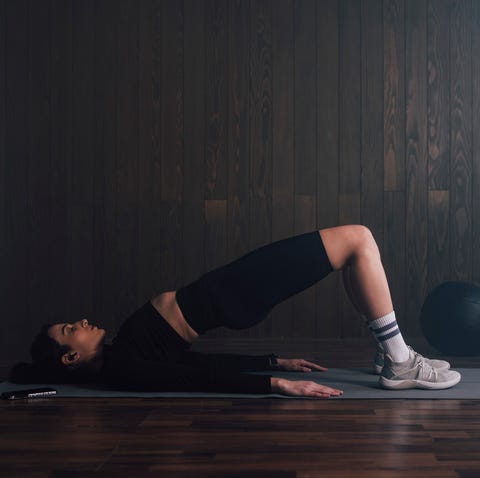 Side View of a Female Athlete Doing an Exercise on the Floor side view of a female athlete doing an exercise on the floor