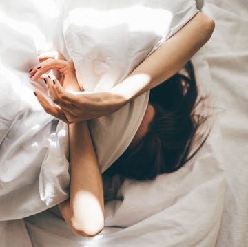 sleepless woman lying in bed hiding under duvet sleepless woman lying in bed hiding under duvet