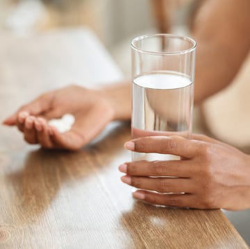 Unrecognizable black woman takes medicines with glass of water at home unrecognizable black woman takes medicines with glass of water at home
