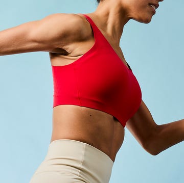 athlete in motion wearing a red sports bra and beige leggings athlete in motion wearing a red sports bra and beige leggings