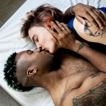 A young LGBT couple kissing and hugging in bed a young lgbt couple kissing and hugging in bed
