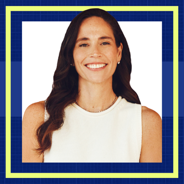 Smiling woman with long dark hair in a white top against a blue geometric background.