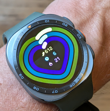close up of a smartwatch displaying activity data and settings on a person's wrist.
