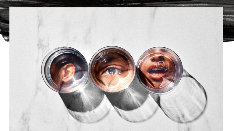 Three clear glasses reflect ears, an eye, and a mouth against a marbled background, casting shadows. Three clear glasses reflect ears, an eye, and a mouth against a marbled background, casting shadows.