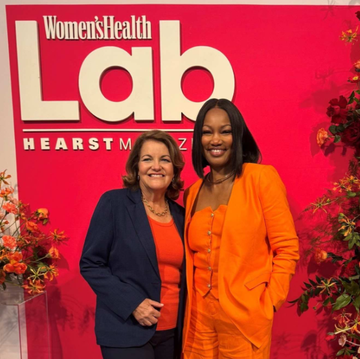 two women posing in front of a promotional backdrop for womens health lab two women posing in front of a promotional backdrop for womens health lab