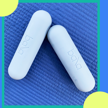 Two light gray Bala fitness weights on a blue textured background.